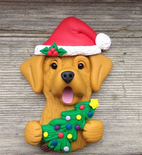A Yellow Dog Wearing A Santa Hat And Holding A Christmas Tree Ornament