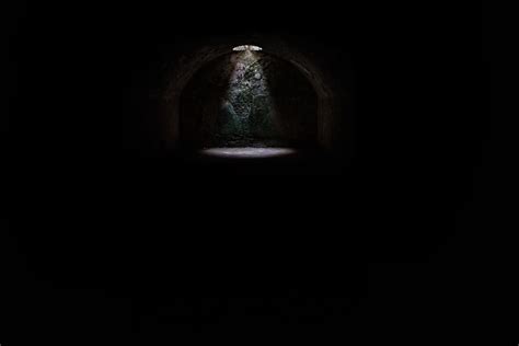 A Spotlight Coming From A Hole In A Dark Underground Cave
