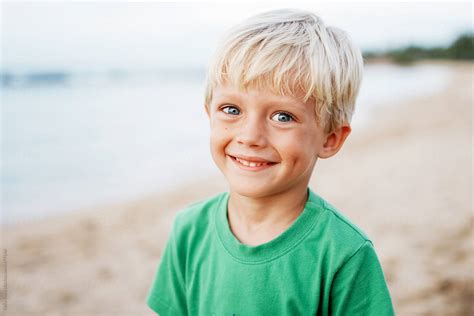 Portrait Of A Smiling Boy On The Beach Del Colaborador De Stocksy
