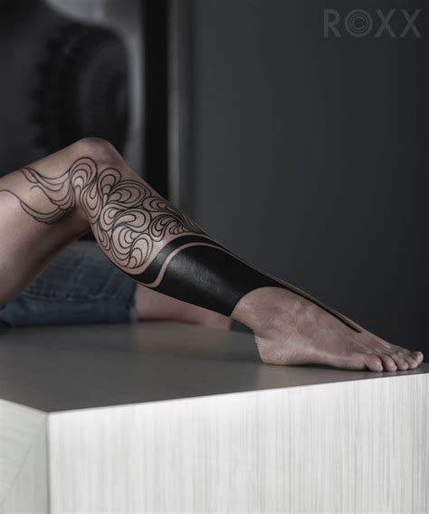 This tattoo utilizes black and gray geometric shapes connected by black and red lines on the back of the wearer's calves. Tattoo on Leg For Female | Best Tattoo Ideas Gallery
