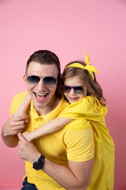Lindo Padre E Hija En Amarillo Y Gafas De Sol Abrazando Sobre Fondo De Color Rosa Concepto De