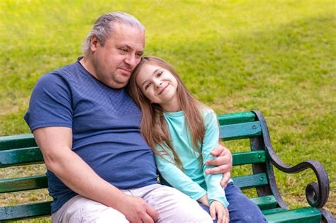 Padre E Hija Abrazándose Mientras Están Sentados En Un Banco Del Parque