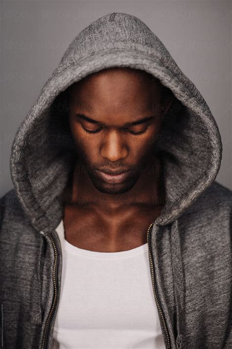 Young African Man In Hoodie Looking Down By Stocksy Contributor