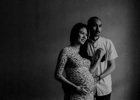 premium photo man with pregnant wife standing against wall