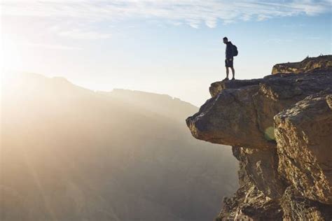 960 Man Standing On The Edge Of A Cliff Stock Photos Pictures
