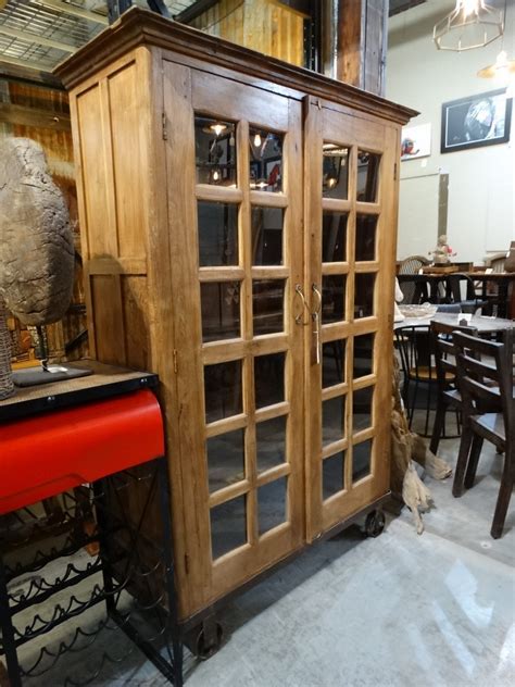 Natural Wood Cabinet With Glass Doors Has Wheels