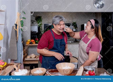 Asian Couple Standing In The Kitchen They Are Playing Dough And Happy Together Stock Image
