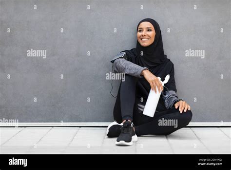 Happy Sporty Muslim Woman In Hijab Relaxing After Fitness Training