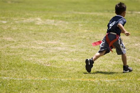 Little Boy Kid Playing Flag Football On An Open Field Stock Image