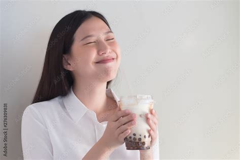 happy smiling asian woman drinking iced bubble milk tea aka boba tea pearl milk tea tapioca