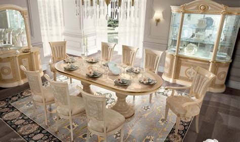 This set includes a tabletop and trestle base featuring a glossy beige finish that is crafted from a blend of solid rubberwood with manufactured wood. Aida Dining Room Set in Beige and Gold Finish Made in Italy