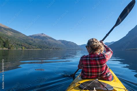 Foto De Young Woman Paddling A Kayak Touring The Lakes Of The National