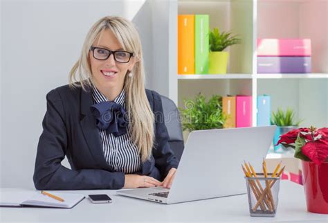 Portrait Of Woman Sitting At Desk In Office Stock Photo Image Of