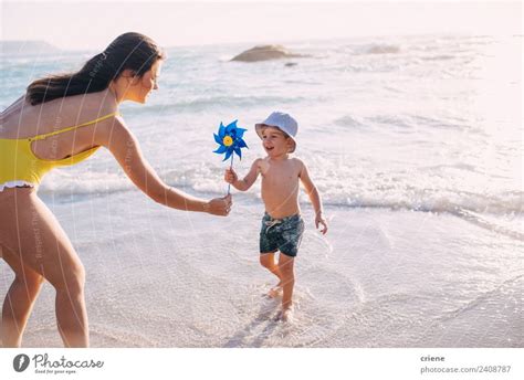 Kaukasische Mutter Und Sohn Beim Spielen Mit Der Windm Hle Am Strand