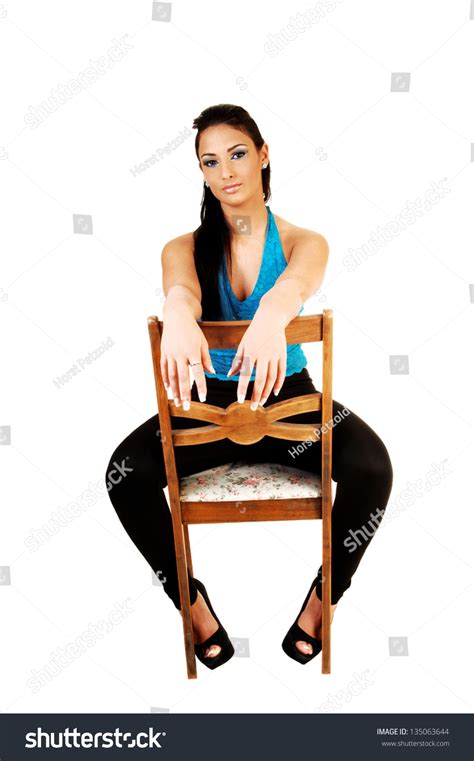 A Young Teenage Girl Sitting Backwards On A Chair In A Blue Corset And