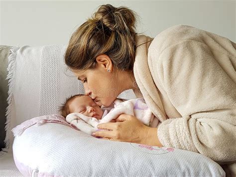 Cuidadosa Madre Besando A Su Hija Mientras Duerme Imagen De Archivo