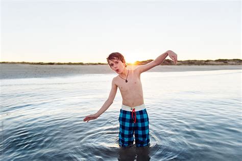 Whistling Boy Dancing In Shallow Water At The Beach At Sunset By Stocksy Contributor Angela