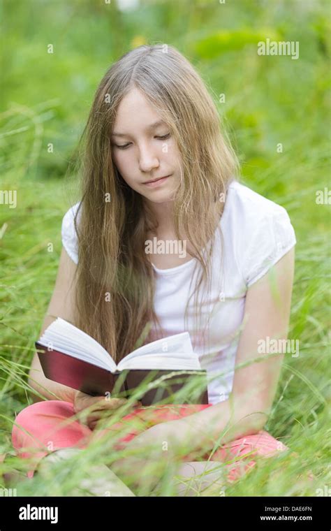 Young Girl Reading Book On Field Vertical Photo Stock Photo Alamy