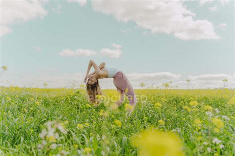 Young Woman Bending Over Backwards In A Flower Meadow In Spring — Peace