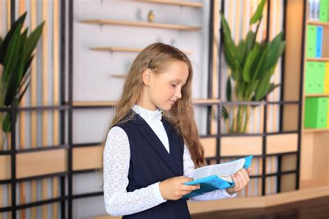 Portrait Of A Girl In A School Uniform With A Book In Her Hands Stock