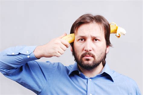 Young Man Blowing Up His Brain With Banana Royalty Free Stock Image