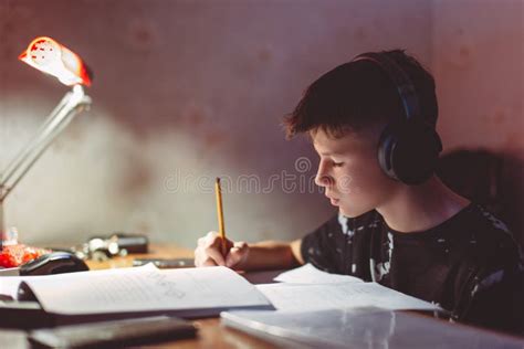 Little Diligent Boy Doing His Homework While Listening Music By