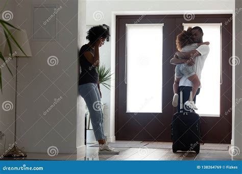 Sad African Father Hugging Little Daughter before Leaving Family Stock