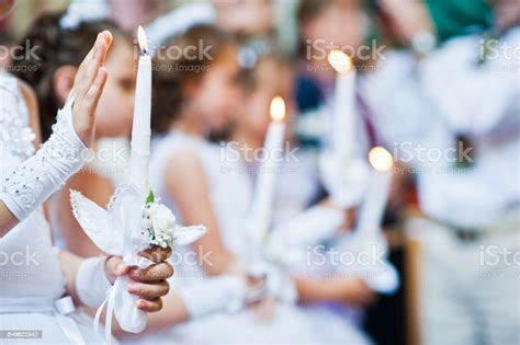 Hands With Candles Of Little Girls On First Holy Communion Stock Photo
