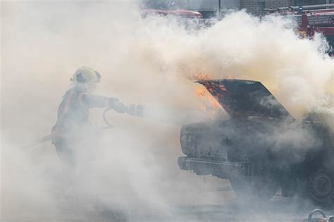 Premium Photo A Firefighter Extinguishes A Car With A Fire Extinguisher Fire Extinguisher