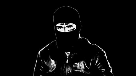 A Man In A Balaclava Pointing The Gun Into Camera And Pulling The