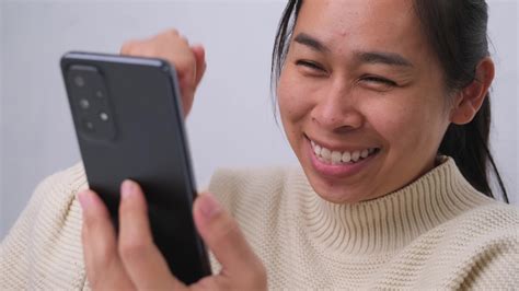 Portrait Of Happy Woman Enjoying Success On Mobile Phone At Home Close
