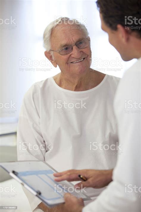 Doctor Talking With Older Patient In Hospital Room Stock Photo
