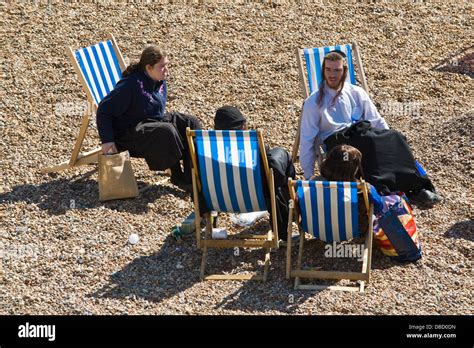 Orthodox Hasidic Jews Holidaymakers Relax In Deckchairs In Summer Sunshine On The Beach At