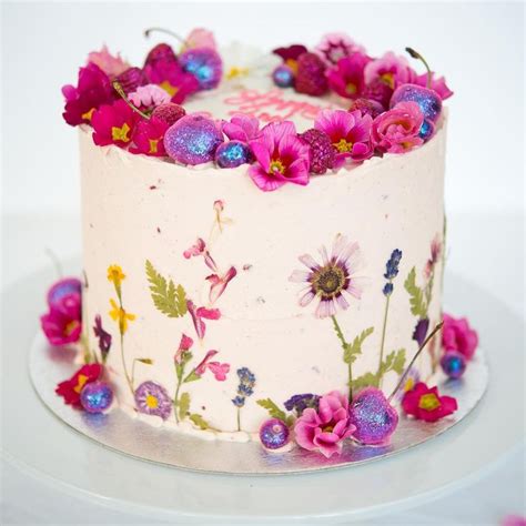 A White Cake With Pink And Purple Flowers On It