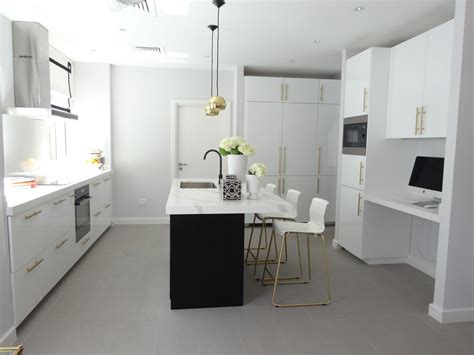 White walls, stainless steel appliances, and lots of natural light brighten up this kitchen with black cabinets. Black & white kitchen with brass and gold accessories ...