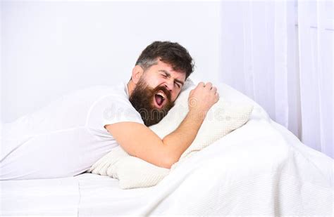 Man In Shirt Laying On Bed White Wall On Background Nap And Siesta