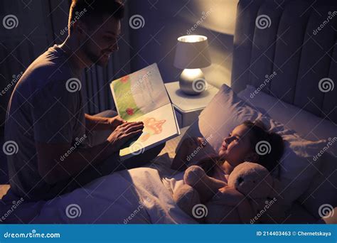 father reading bedtime story to his daughter at home stock image image of adult home 214403463