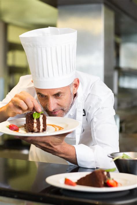 Concentrated Male Pastry Chef Decorating Dessert In Kitchen Stock Image