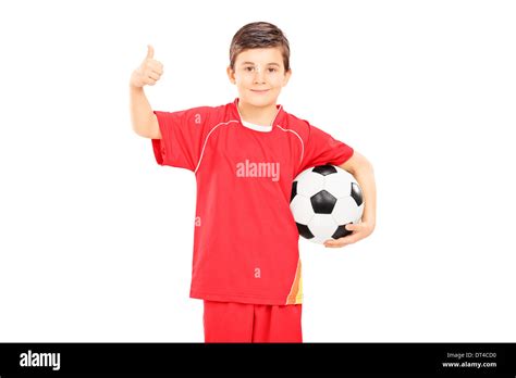 Boy In Sportswear Holding A Football And Giving Thumb Up Stock Photo