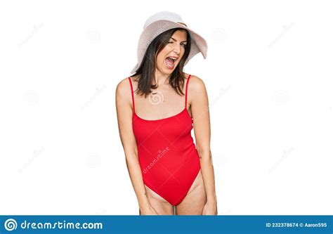 Beautiful Brunette Woman Wearing Swimsuit And Summer Hat Winking Looking At The Camera With