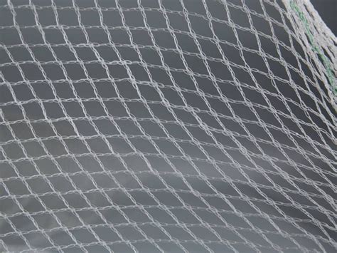 A Piece Of Transparent Plastic Mesh With Diamond Meshes On The Gray