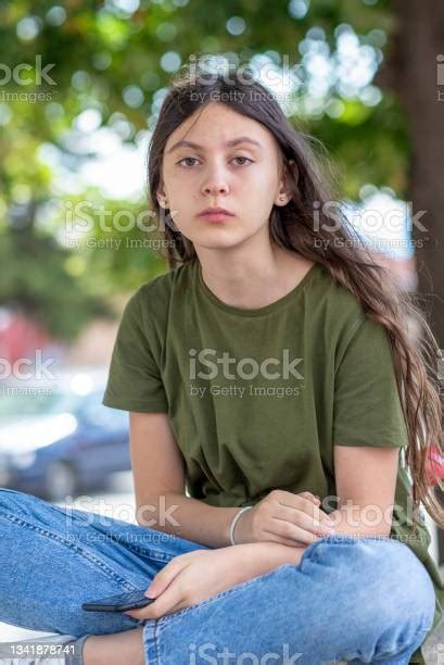 Outdoor Portrait Of A Teenage Girl With Rebellious Expression On Her