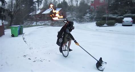 Unicycled Man In Darth Vader Costume Shovels Snow And Plays Flaming