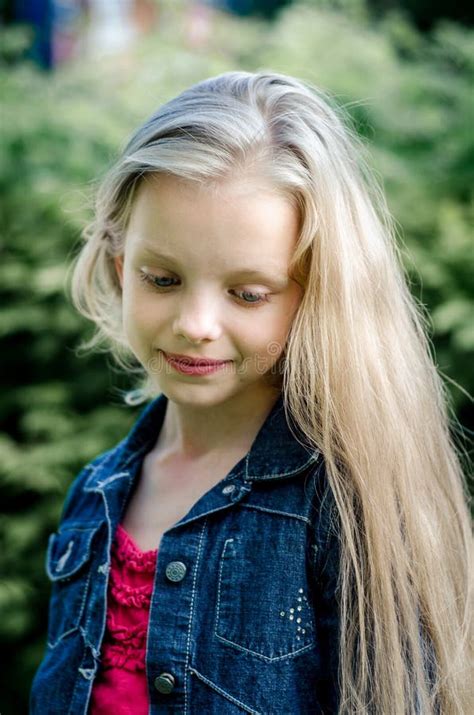 Portrait Of A Beautiful Blonde Little Girl With Long Hair Stock Photo