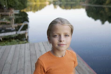 Portrait Of A Young Girl Standing On A Wooden Jetty Stock Photo