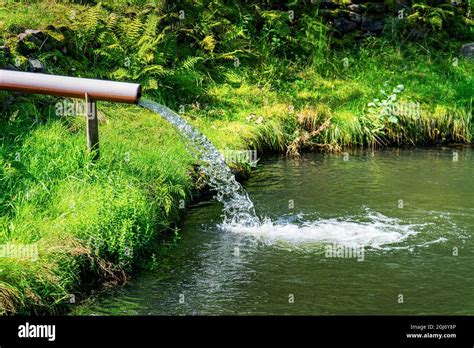 Water Flows Through A Pipe Into Lake Stock Photo Alamy