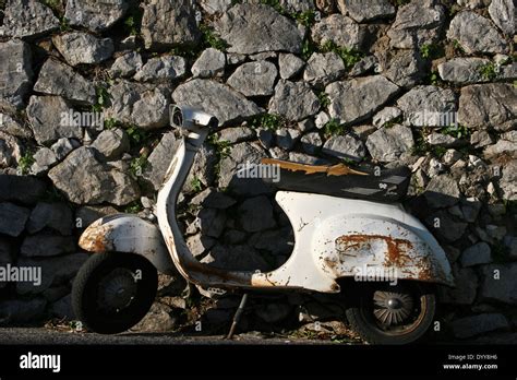 Rusty Italian Motor Bike Leaning Against A Gray Stone Wall At Ravello
