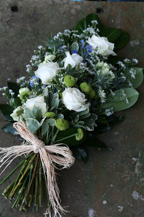 The funeral flower shop delivers floral wreaths casket flowers and funeral flower arrangements to church services, homes and businesses. Cream rose and blue thistle sheaf funeral tribute - an ...