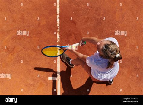 Top view of a professional female tennis player serves the tennis ball