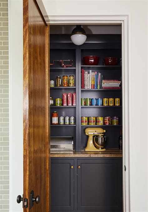 Hang them in kitchens, bedrooms, and living areas to stow necessities or exhibit favorite finds and artwork. Pantry Walk in pantry with navy blue back cabinets and open shelves painted in a Benjamin Moore ...